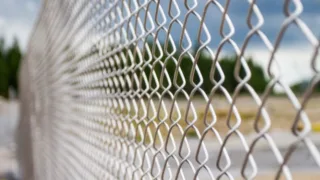 Close-up of a chain-link fence surrounding an outdoor area.