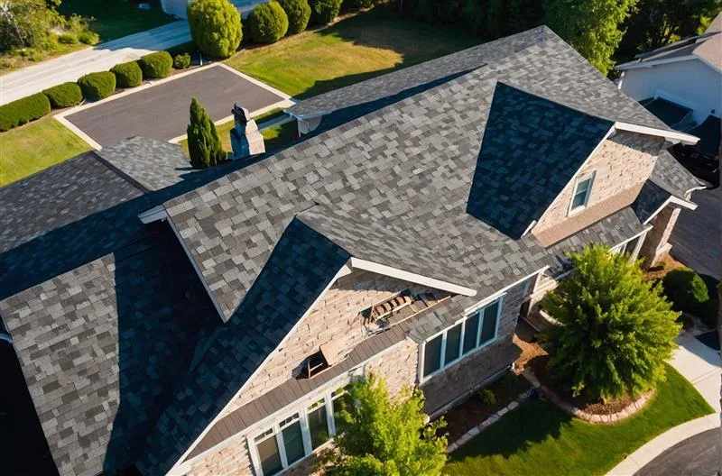 Aerial view of a house featuring grey architectural asphalt shingles and high-quality roofing installation
